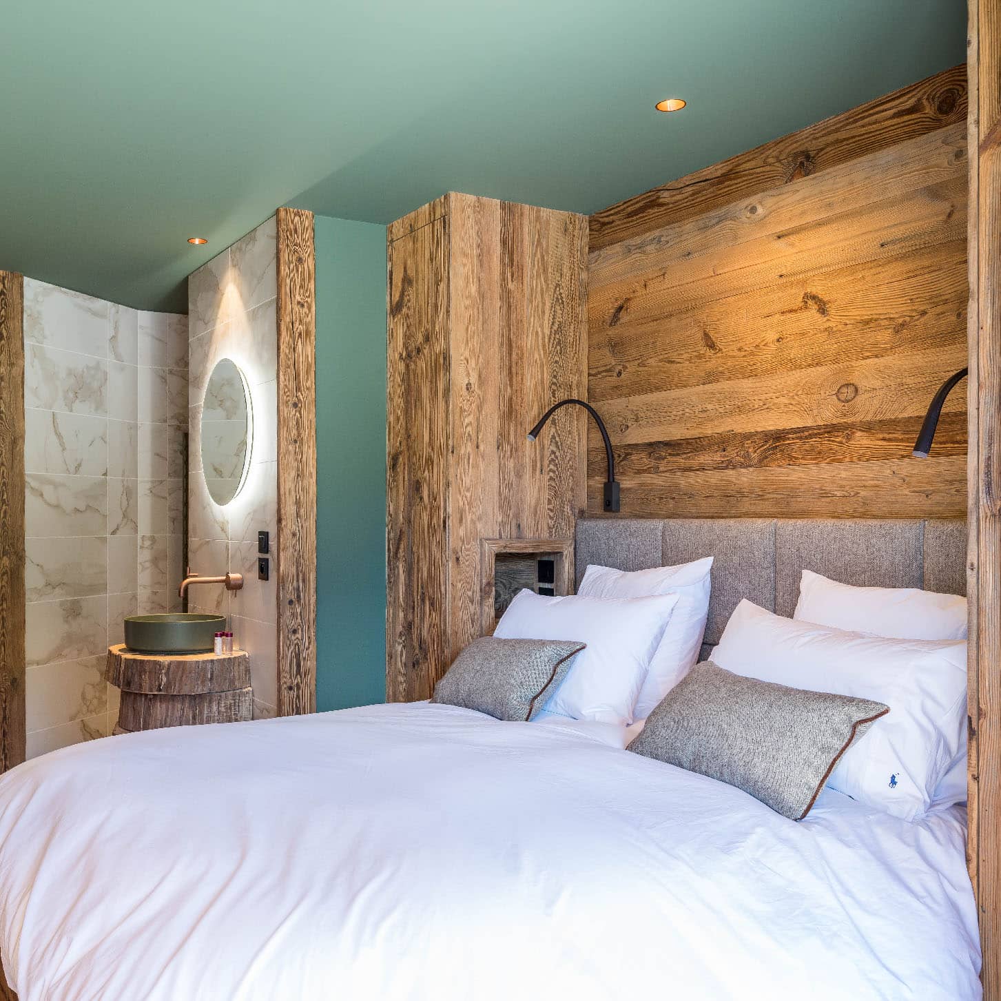 Chambre 2 de 13m² avec lit double 160x200cm, décorée en beige, cuivre, vert agave et laine marron pour une ambiance chaleureuse. Équipée de TV, terrasse avec vue montagne et douche italienne 90x140cm, location chalet 2 Alpes