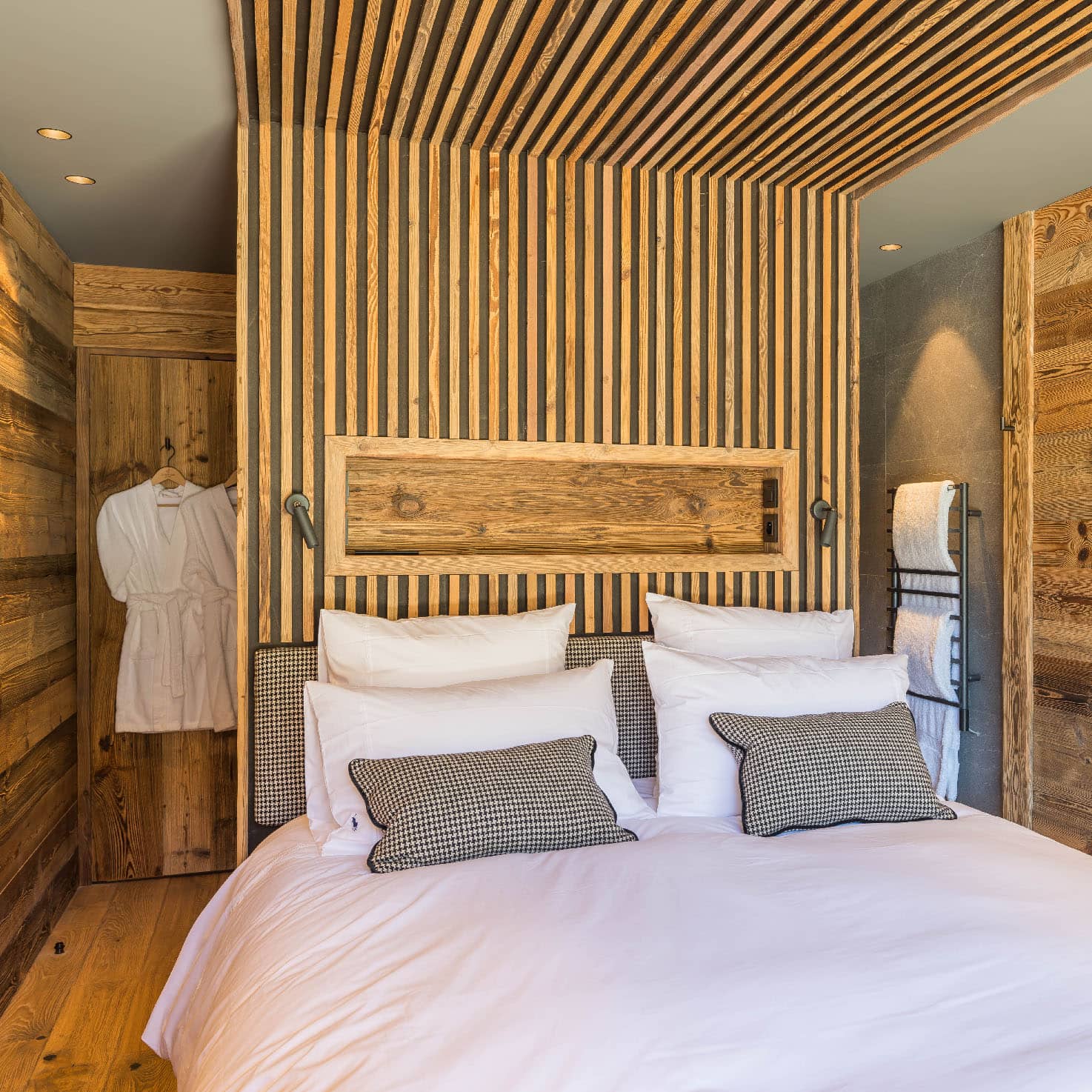 Chambre 3 de 15m², élégamment décorée avec des teintes grises, mat gun et laine pieds de poule N&B. Comprend un lit double 160x200cm, TV, terrasse avec vue montagne, et une douche italienne 90x140cm. Communicante avec la chambre 4, location chalet 2 Alpes