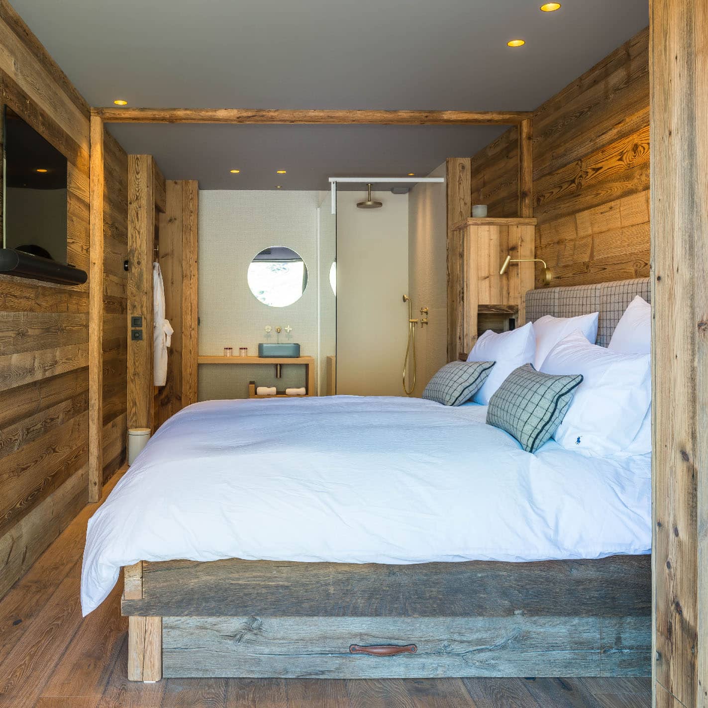 Chambre 4 de 17m², décorée en bleu clair, or brossé doux, taupe et laine à carreaux bleus. Comprend un lit double 180x200cm aménageable en twin, TV, terrasse avec vue montagne, et une douche italienne 90x150cm. Communicante avec la chambre 3, location chalet 2 Alpes