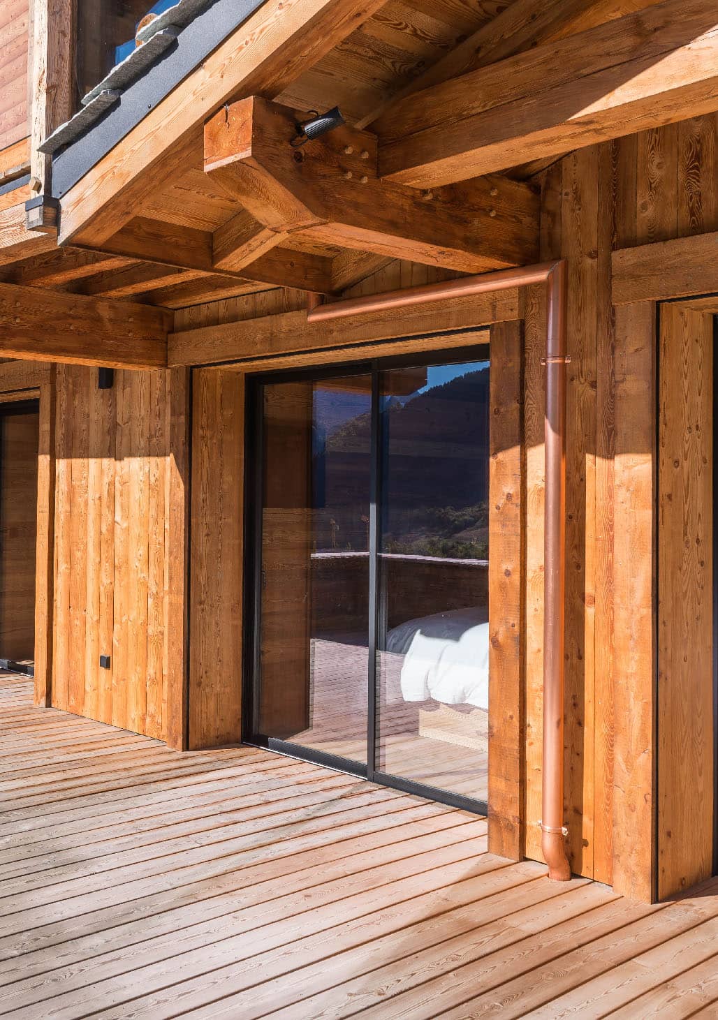 Vue extérieure du chalet avec aperçu d'une chambre à travers la fenêtre, location chalet 2 Alpes