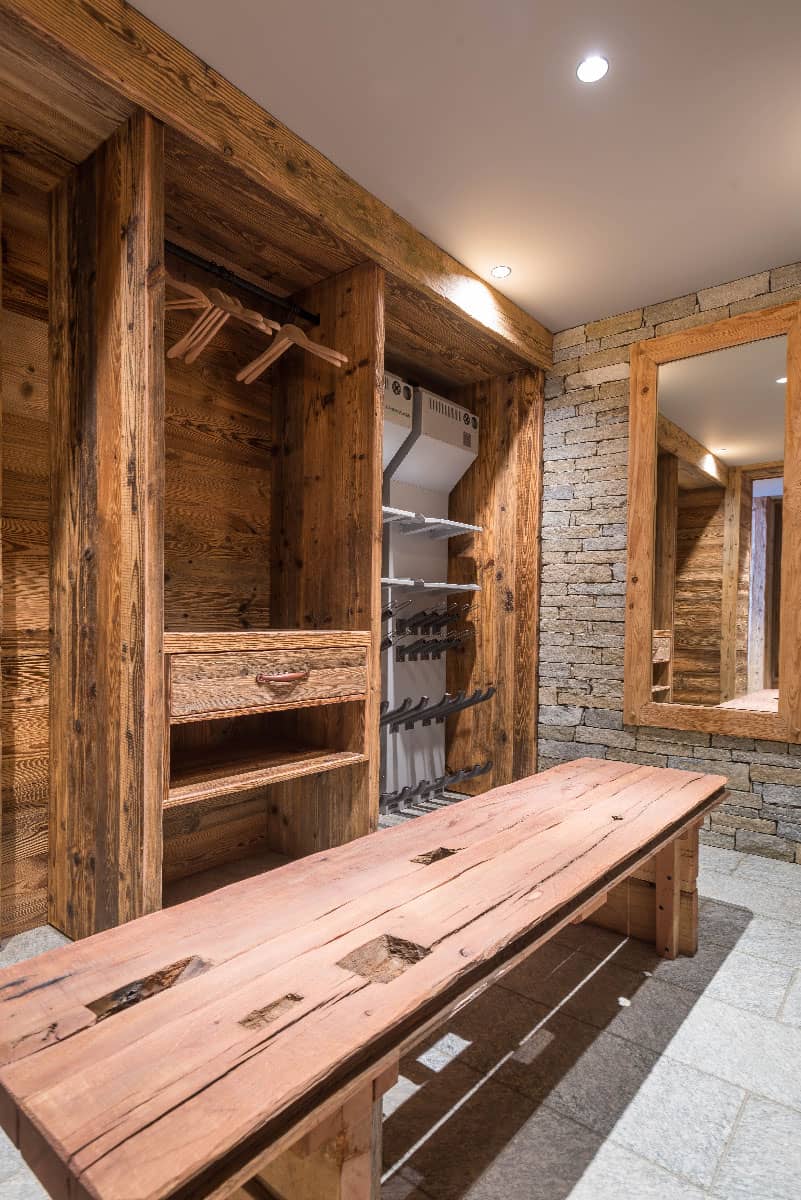 Ski room du Chalet du Lièvre Blanc avec chauffage au sol et espace de rangement élégant pour équipements de glisse. Capable d'accueillir jusqu'à 16 équipements simultanément, avec installations de séchage Wintersteiger® pour chaussures, gants et casques, offrant confort et préparation optimale après une journée sur les pistes, location chalet 2 Alpes